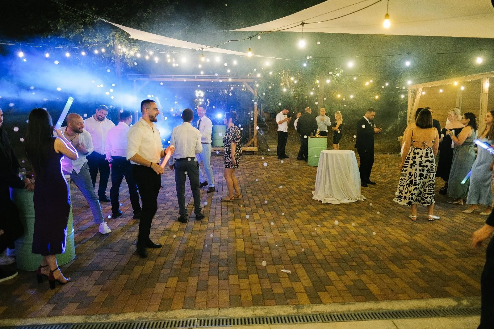 Ringul de dans noaptea, invitați petrecând sub ghirlande luminoase